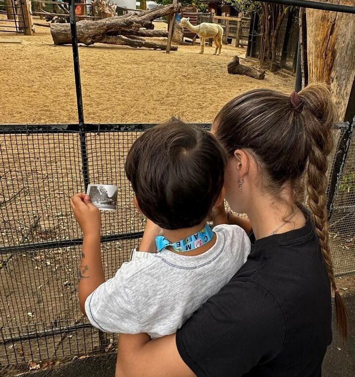 Raquel with a child she cared for as a nanny, on a day out at the zoo